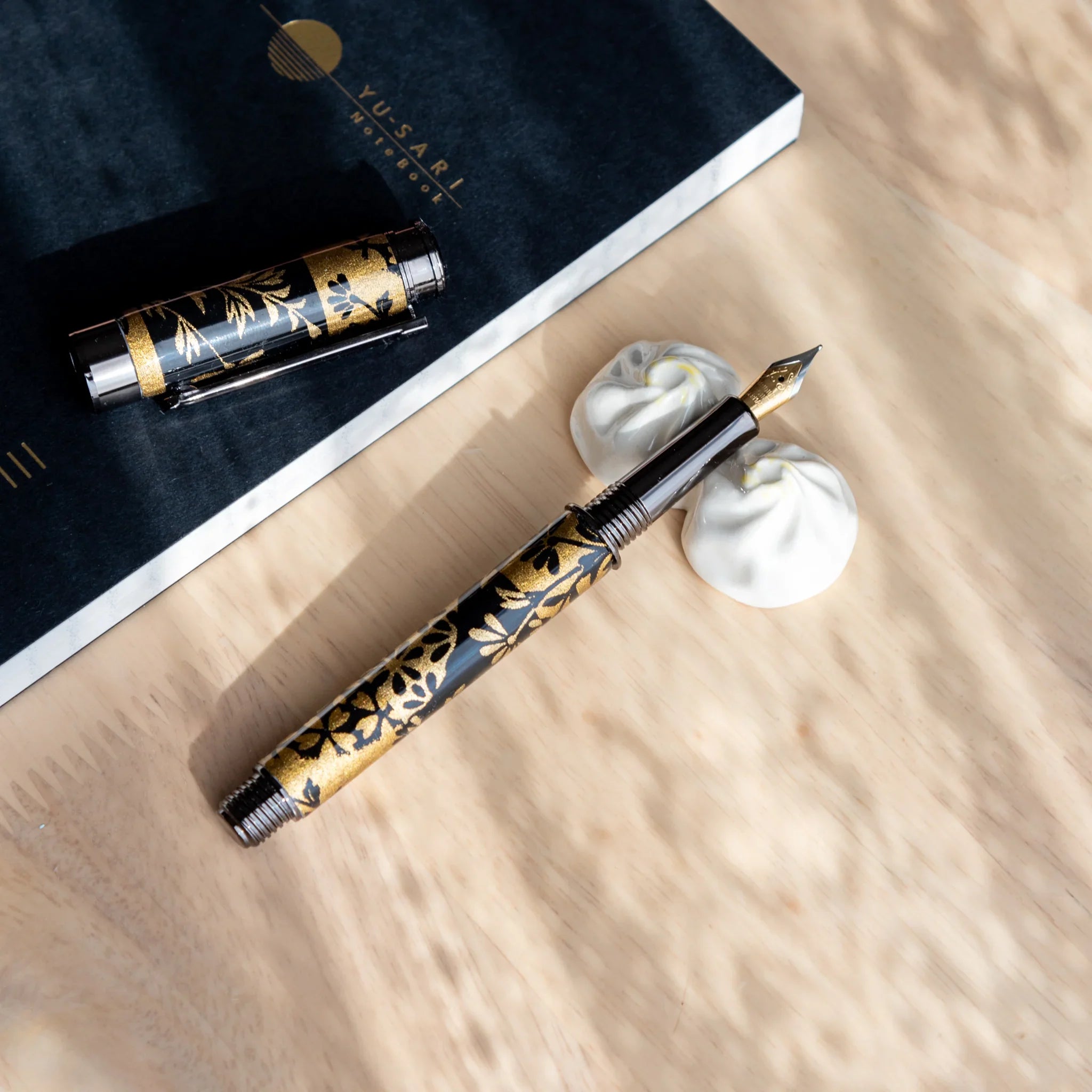 Xiaolongbao handcrafted ceramic pen rest showing detailed dumpling shape from overhead photographed view close shot