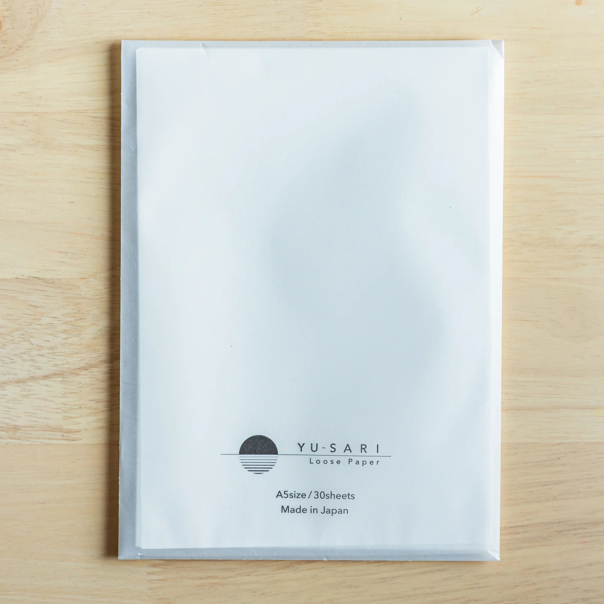 YU-SARI loose leaf paper sheets flat lay arrangement on natural surface showing paper whiteness and crisp edges
