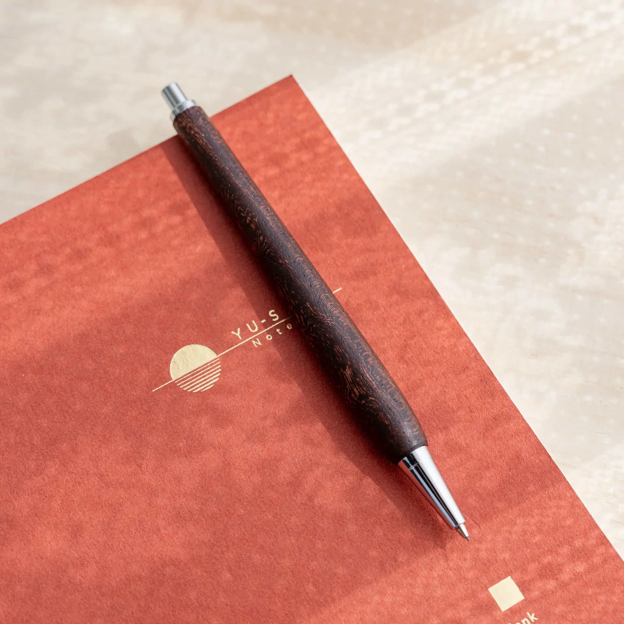 Dark reddish-brown zelkova wood urushi mechanical pencil, close-up of silver cone tip, Japanese keyaki wood barrel