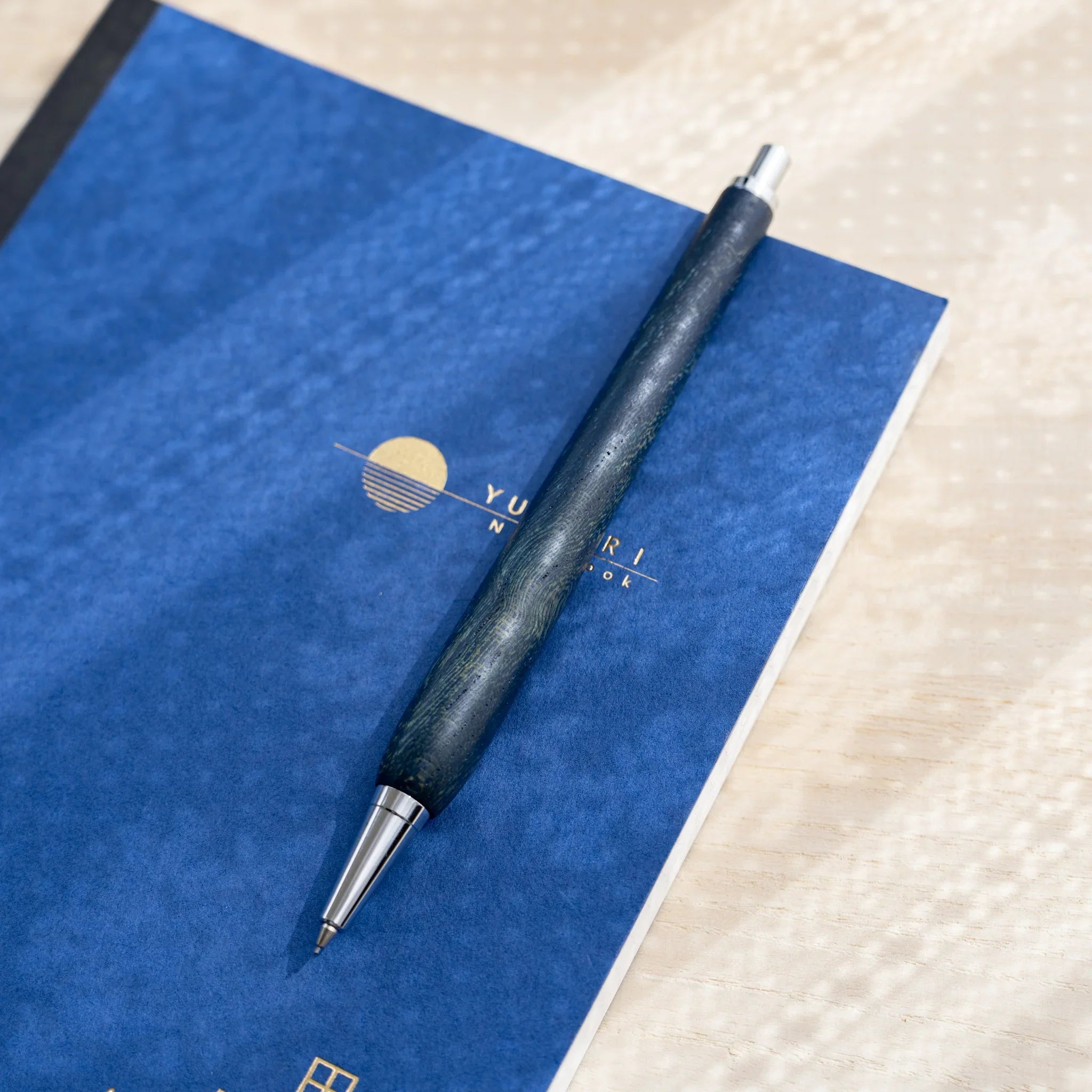 Indigo blue zelkova wood urushi mechanical pencil, close-up of knock button and clip, Japanese keyaki wood grain