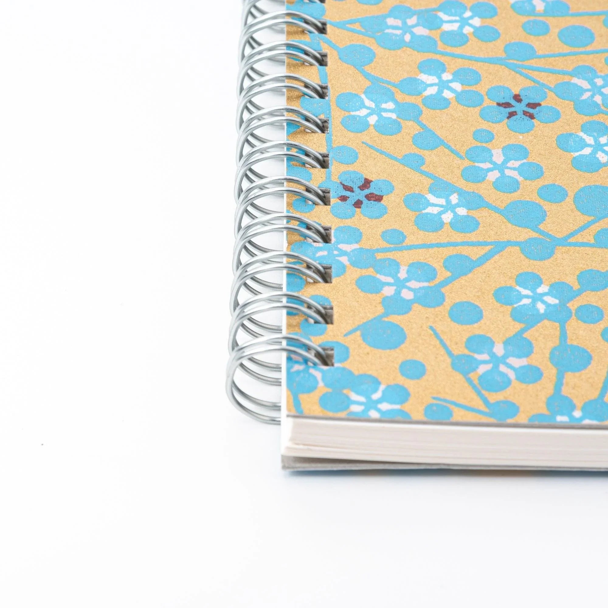 Close-up of blue hand-dyed Yuzen washi notebook cover displaying flower dye pattern and paper texture detail