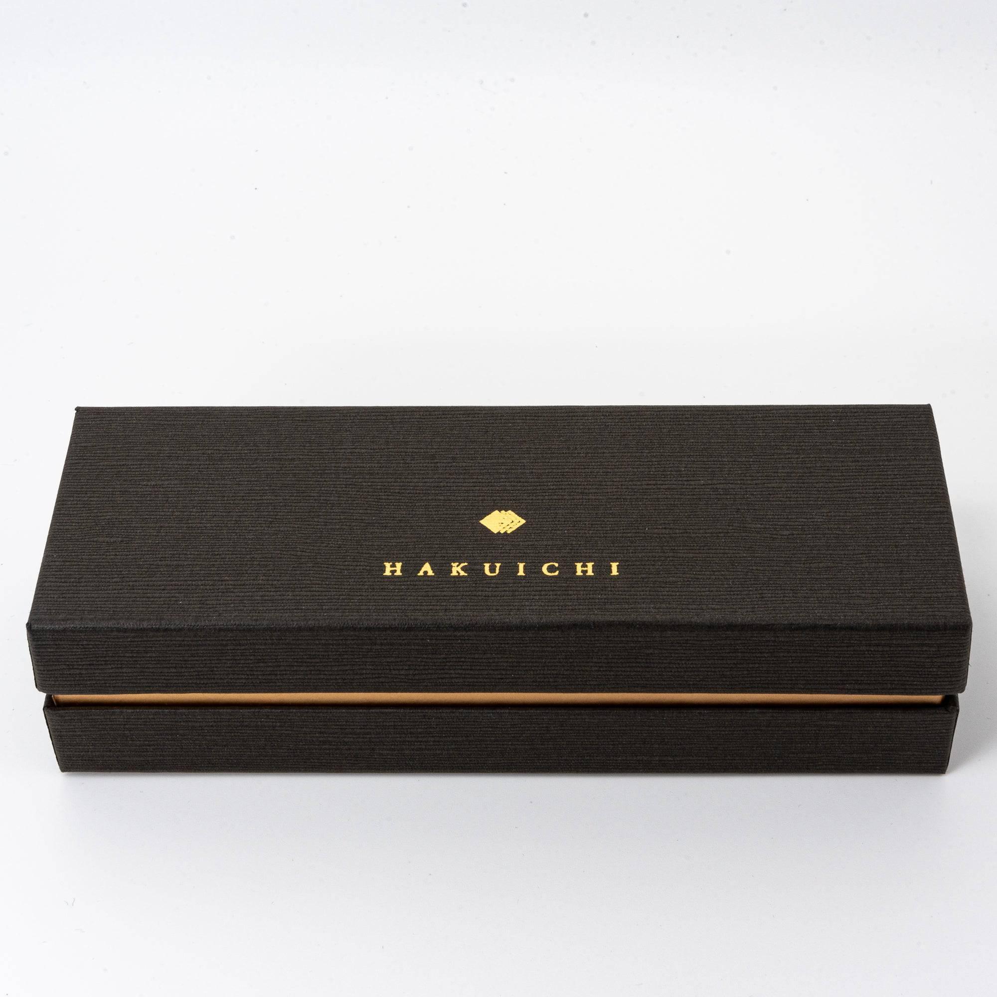 Japanese brown ballpoint pen in kraft presentation box with cream tissue lining and ribbon, top view