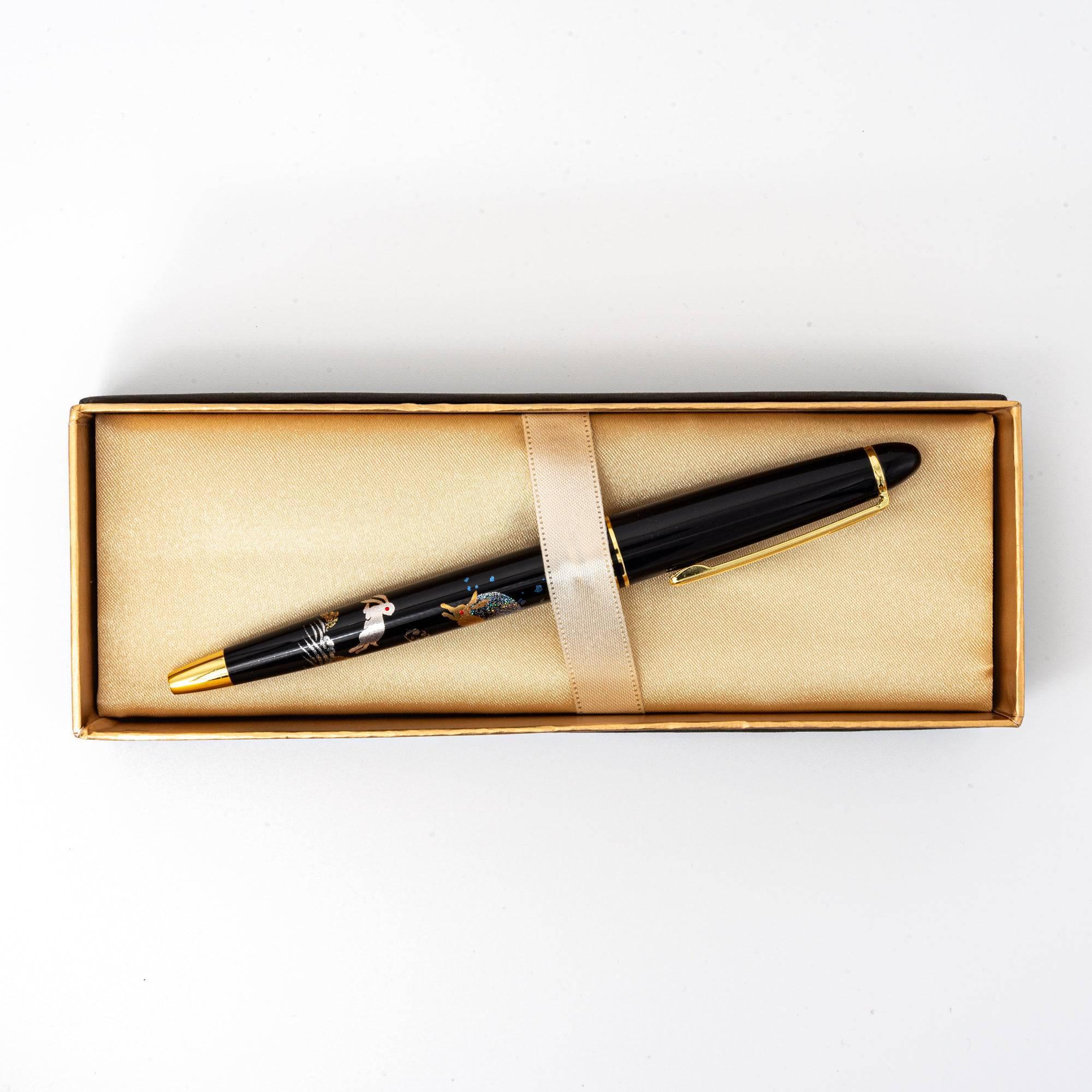 Japanese ballpoint pen kraft box with black lid, gold accents, and cream interior ribbon, top view white background