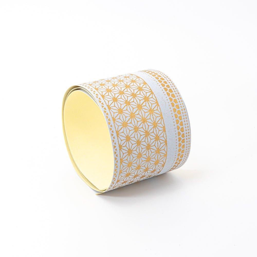 Golden pattern yuzen washi tape upright at angle showing asanoha and kikko gold pattern on grey, yellow adhesive interior