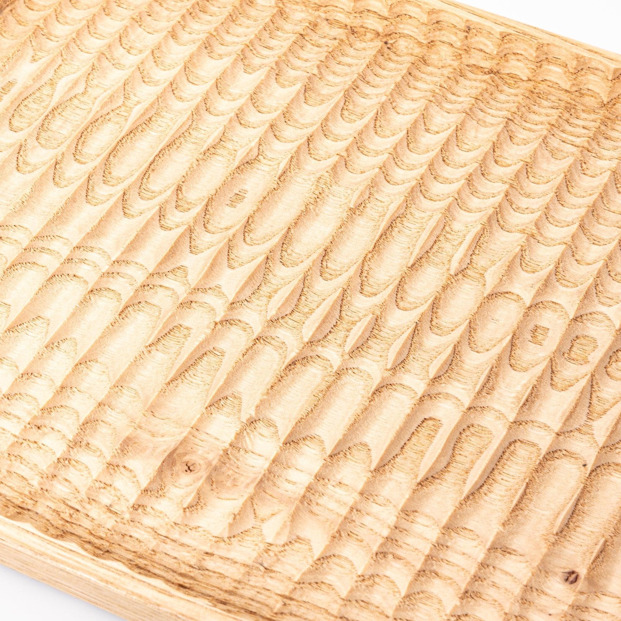 Hand-carved wooden pen tray with fine ridge detailing and natural wood grain pattern visible with clear visibility of design