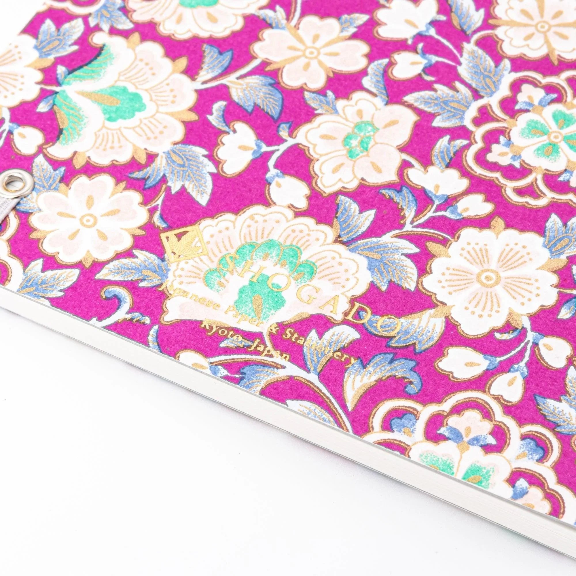 Close-up of magenta washi notebook corner with gold foil Shogado Japanese Paper Stationery Kyoto Japan imprint on the cover