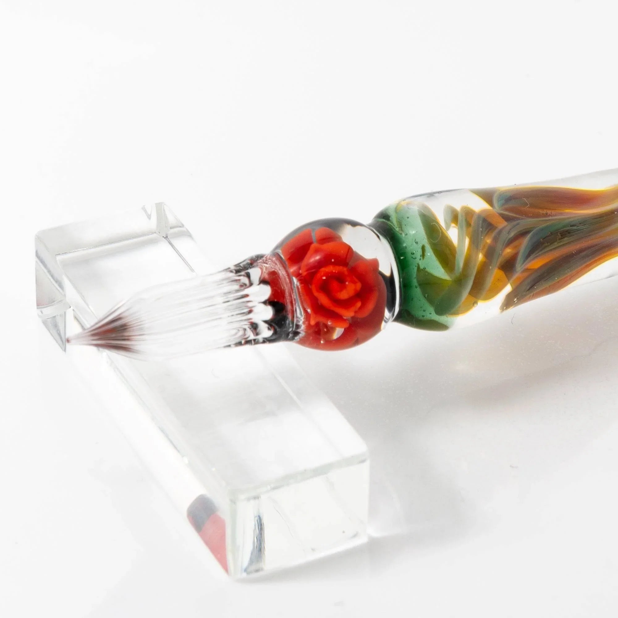 Orange Rose glass dip pen positioned for calligraphy use displaying metal nib and orange glass material with holder