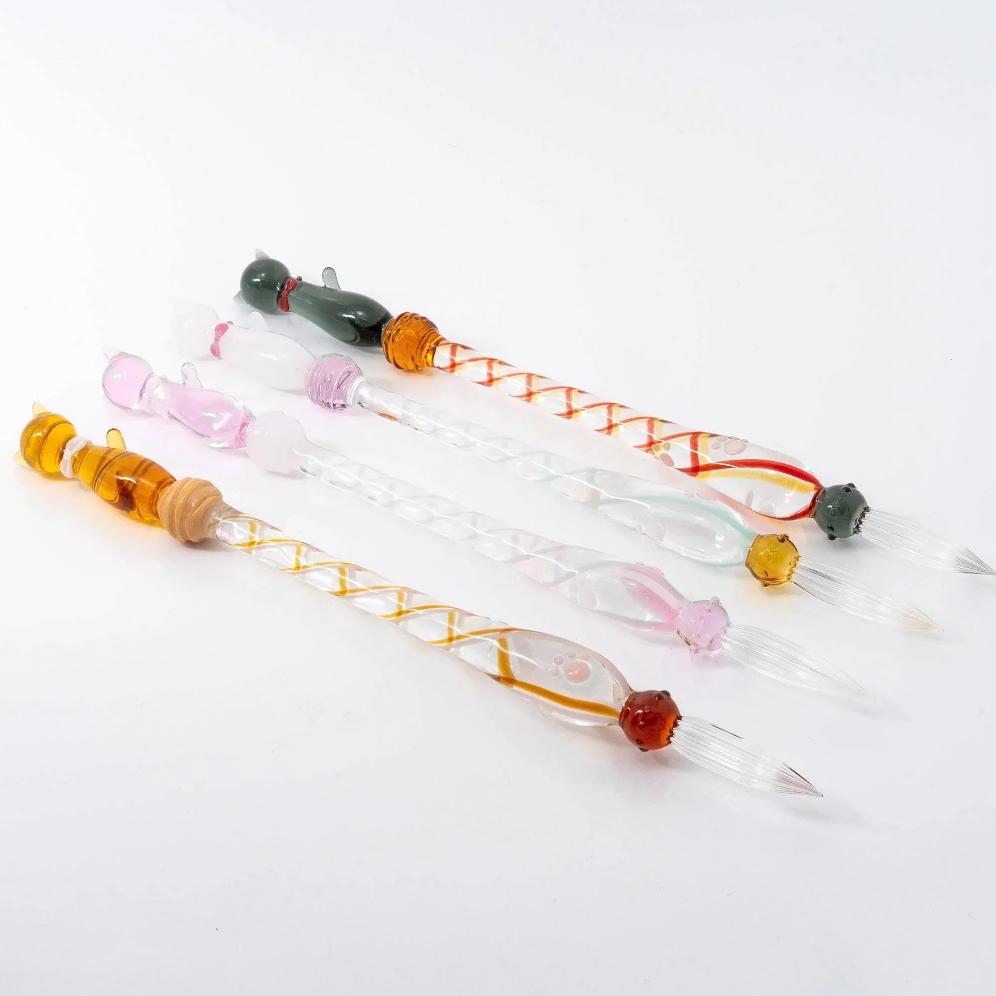 White Nyanko cat sitting on clear transparent glass dip pen handle showing full barrel composition angle